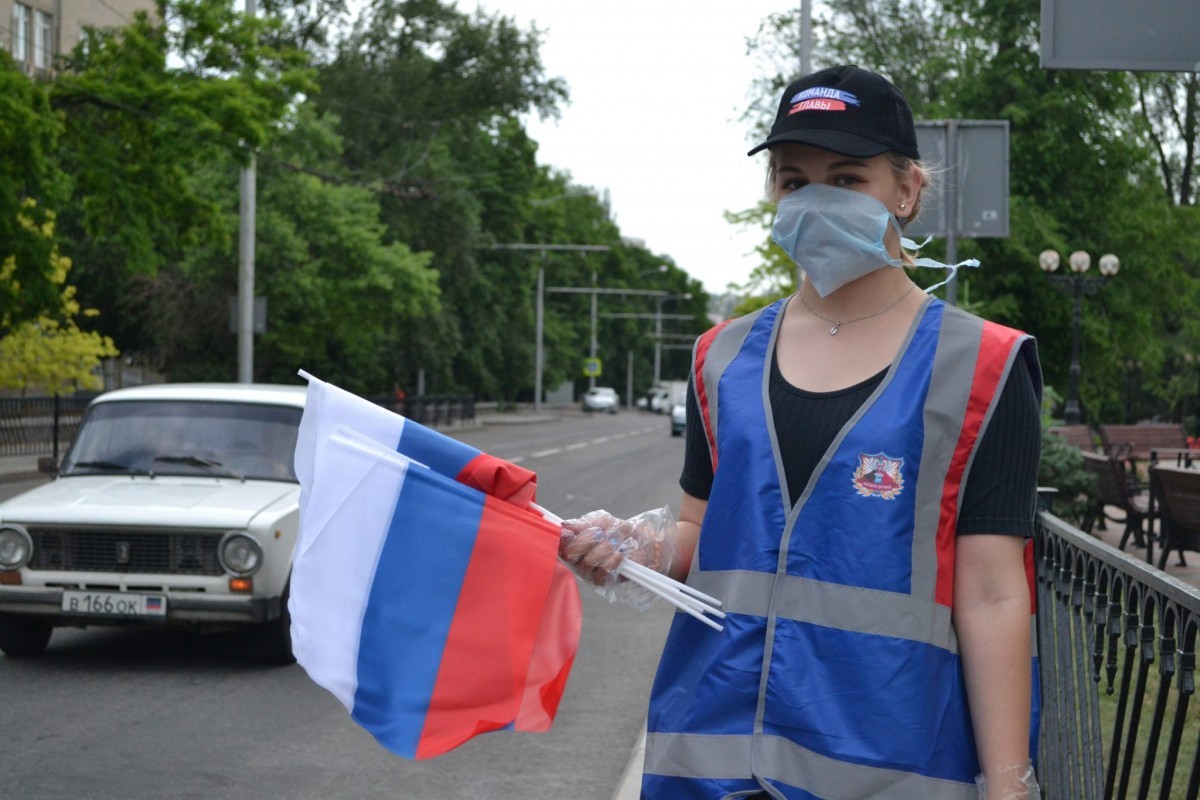 Активисты ОД «ДР» раздают ленточки и флажки в цветах российского триколора в Донецке